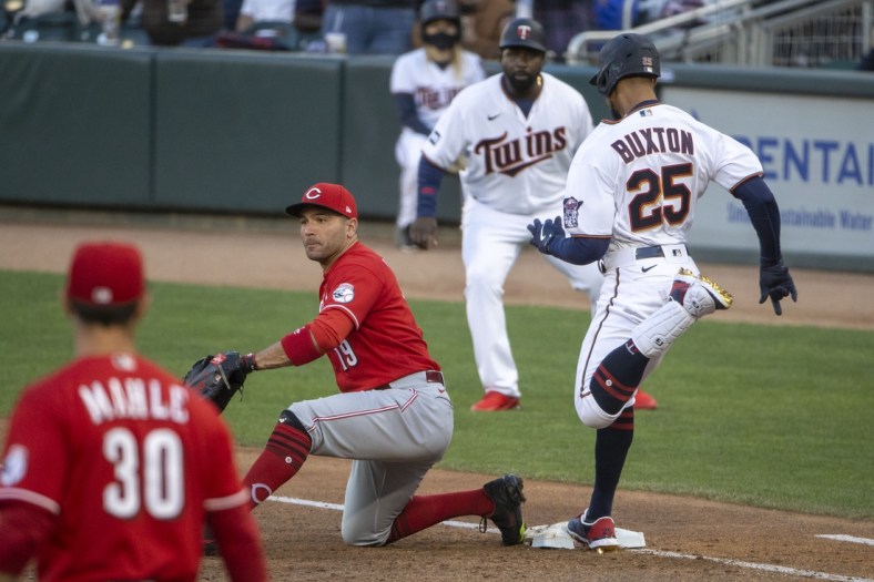 Jun 21, 2021; Minneapolis, Minnesota, USA; Minnesota Twins center fielder Byron Buxton (25) reaches first base before Cincinnati Reds first baseman Joey Votto (19) can catch the ball for a single in the second inning at Target Field. Mandatory Credit: Jesse Johnson-USA TODAY Sports