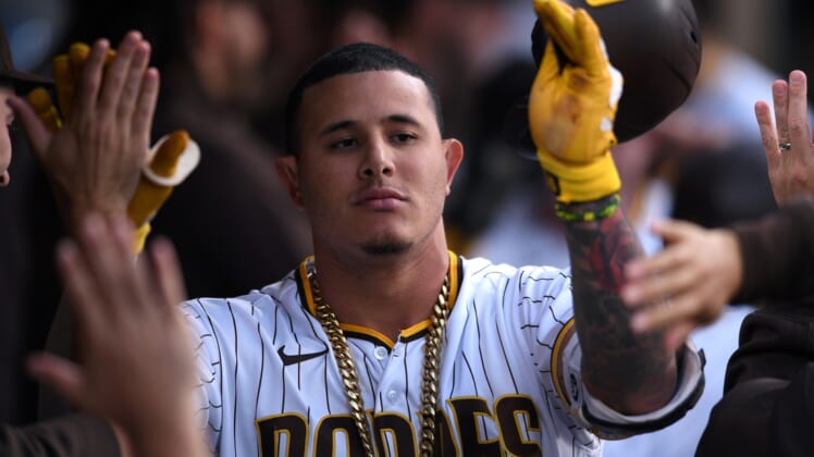 Jun 21, 2021; San Diego, California, USA; San Diego Padres third baseman Manny Machado (13) is congratulated in the dugout after hitting a three-run home run during the first inning against the Los Angeles Dodgers at Petco Park. Mandatory Credit: Orlando Ramirez-USA TODAY Sports