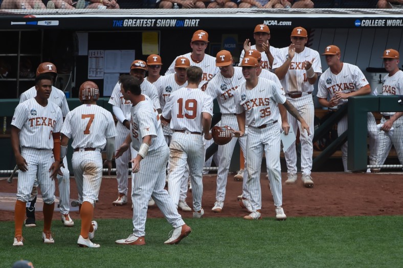 Jun 22, 2021; Omaha, Nebraska, USA; The Texas Longhorns bench celebrates with outfielder Douglas Hodo (7) and infielder Mitchell Daly (19) after scoring in the fourth inning against the Tennessee Volunteers at TD Ameritrade Park. Mandatory Credit: Steven Branscombe-USA TODAY Sports