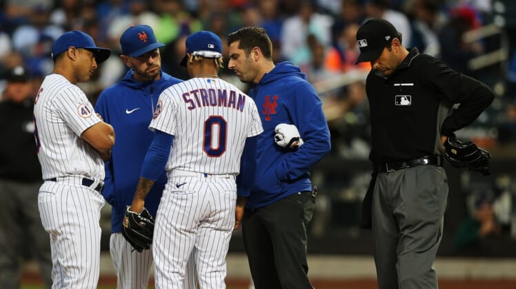 Jun 22, 2021; New York City, New York, USA;  New York Mets starting pitcher Marcus Stroman (0) is attended to after getting injured against the Atlanta Braves during the second inning at Citi Field. Mandatory Credit: Andy Marlin-USA TODAY Sports