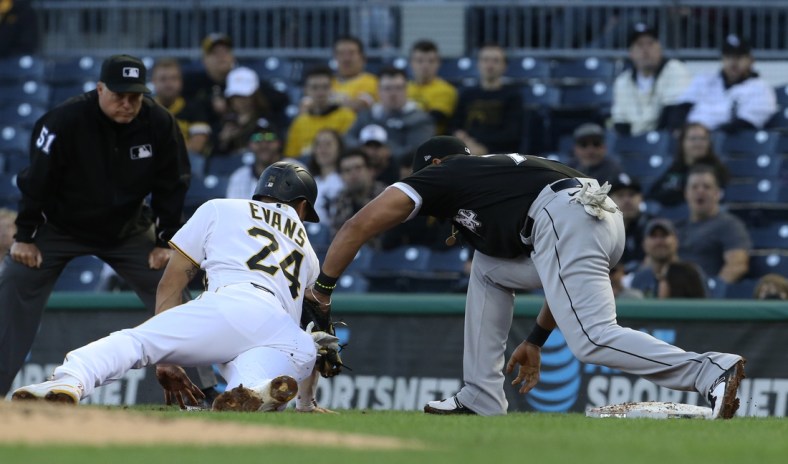 Jun 22, 2021; Pittsburgh, Pennsylvania, USA;  Pittsburgh Pirates left fielder Phillip Evans (24) is tagged out at first base by Chicago White Sox first baseman Jose Abreu (79) on a pick-off during the second inning at PNC Park. Mandatory Credit: Charles LeClaire-USA TODAY Sports