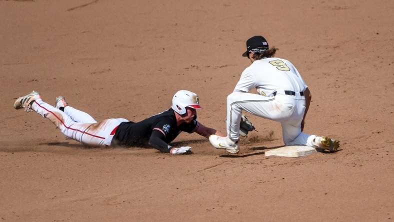 Jun 25, 2021; Omaha, Nebraska, USA;  Vanderbilt Commodores infielder Carter Young (9) tags out NC State Wolfpack first baseman Sam Highfill (17) on a pick off in the seventh inning at TD Ameritrade Park. Mandatory Credit: Steven Branscombe-USA TODAY Sports