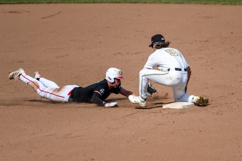 Jun 25, 2021; Omaha, Nebraska, USA;  Vanderbilt Commodores infielder Carter Young (9) tags out NC State Wolfpack first baseman Sam Highfill (17) on a pick off in the seventh inning at TD Ameritrade Park. Mandatory Credit: Steven Branscombe-USA TODAY Sports