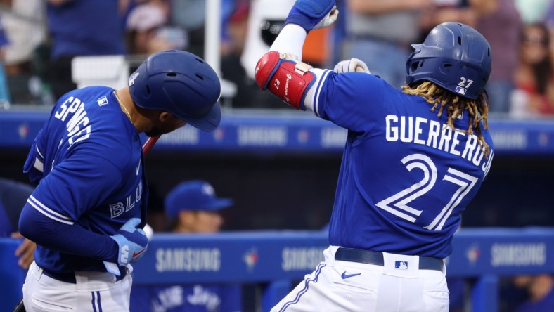 Jun 25, 2021; Buffalo, New York, USA;  Toronto Blue Jays first baseman Vladimir Guerrero Jr. (27) celebrates his home run with center fielder George Springer (4) during the third inning against Baltimore Orioles at Sahlen Field. Mandatory Credit: Timothy T. Ludwig-USA TODAY Sports