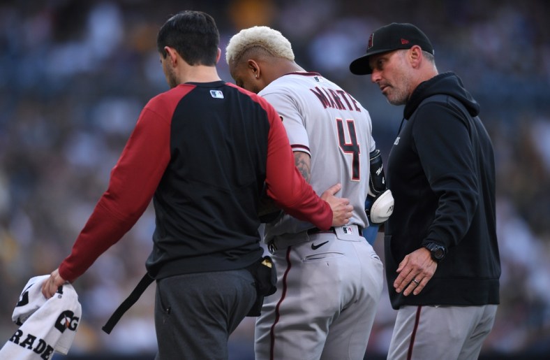 Jun 26, 2021; San Diego, California, USA; Arizona Diamondbacks center fielder Ketel Marte (4) is accompanied off the field by manager Torey Lovullo (right) after an injury during the first inning against the San Diego Padres at Petco Park. Mandatory Credit: Orlando Ramirez-USA TODAY Sports