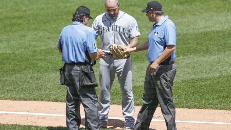 Jun 27, 2021; Chicago, Illinois, USA; Umpires Phil Cuzzi (10) and Mark Ripperger (90) check Seattle Mariners relief pitcher Hector Santiago (57) glove for illegal substance before ejecting him from the a baseball game against the Chicago White Sox during the fifth inning of the first game of a doubleheader at Guaranteed Rate Field. Mandatory Credit: Kamil Krzaczynski-USA TODAY Sports