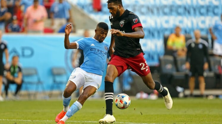 Jun 27, 2021; Harrison, New Jersey, USA; New York City FC forward Thiago Andrade (8) kicks the game-winning goal while D.C. United defender Donovan Pines (23) tries to defend during the second half of a game between D.C. United and NYCFC at Red Bull Arena. Mandatory Credit: Danny Wild-USA TODAY Sports
