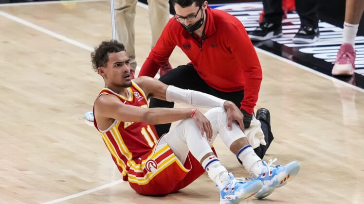 Jun 27, 2021; Atlanta, Georgia, USA; Atlanta Hawks guard Trae Young (11) is attended to after injuring his foot by accidentally stepping on an official's foot against the Milwaukee Bucks in the second half during game three of the Eastern Conference Finals for the 2021 NBA Playoffs at State Farm Arena. Mandatory Credit: Dale Zanine-USA TODAY Sports