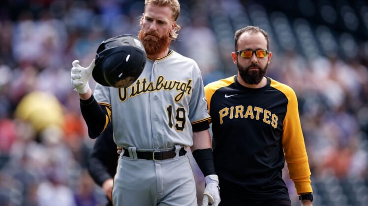 Jun 28, 2021; Denver, Colorado, USA; Pittsburgh Pirates first baseman Colin Moran (19) walks to first with strength and conditioning coach Terence Brannic after being hit by a pitch in the first inning Colorado Rockies at Coors Field. Mandatory Credit: Isaiah J. Downing-USA TODAY Sports