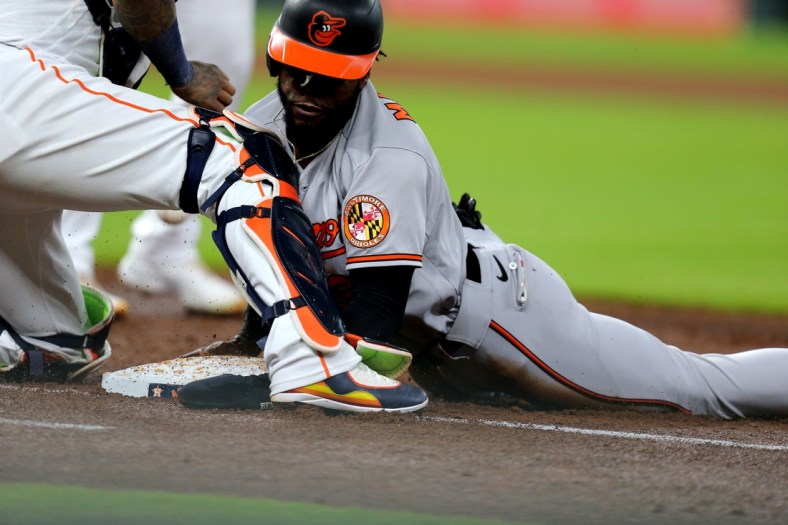 Jun 29, 2021; Houston, Texas, USA; Baltimore Orioles center fielder Cedric Mullins (31) slides into first to avoid a pickoff attempt against the Houston Astros during the third inning at Minute Maid Park. Mandatory Credit: Erik Williams-USA TODAY Sports