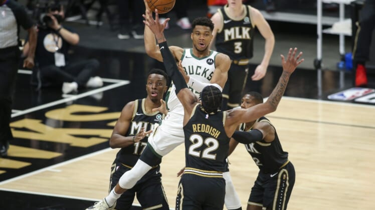 Jun 29, 2021; Atlanta, Georgia, USA; Milwaukee Bucks forward Giannis Antetokounmpo (34) passes over Atlanta Hawks forward Cam Reddish (22) in the first quarter during game four of the Eastern Conference Finals for the 2021 NBA Playoffs at State Farm Arena. Mandatory Credit: Brett Davis-USA TODAY Sports