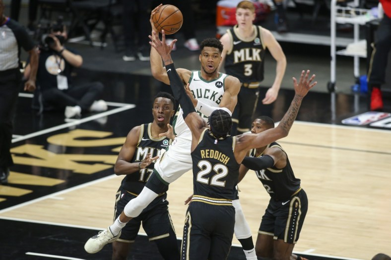 Jun 29, 2021; Atlanta, Georgia, USA; Milwaukee Bucks forward Giannis Antetokounmpo (34) passes over Atlanta Hawks forward Cam Reddish (22) in the first quarter during game four of the Eastern Conference Finals for the 2021 NBA Playoffs at State Farm Arena. Mandatory Credit: Brett Davis-USA TODAY Sports