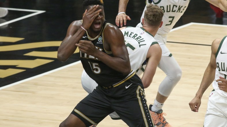 Jun 29, 2021; Atlanta, Georgia, USA; Atlanta Hawks center Clint Capela (15) reaches to being hit in his face against Milwaukee Bucks guard Sam Merrill (15) in the fourth quarter during game four of the Eastern Conference Finals for the 2021 NBA Playoffs at State Farm Arena. Mandatory Credit: Brett Davis-USA TODAY Sports