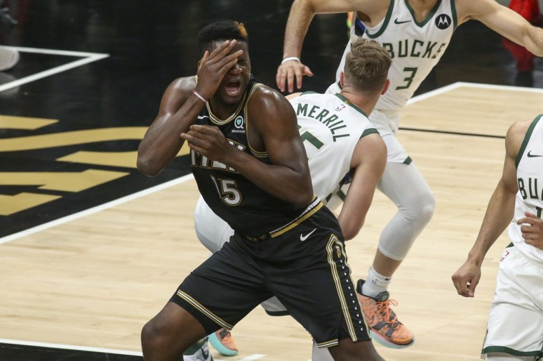 Jun 29, 2021; Atlanta, Georgia, USA; Atlanta Hawks center Clint Capela (15) reaches to being hit in his face against Milwaukee Bucks guard Sam Merrill (15) in the fourth quarter during game four of the Eastern Conference Finals for the 2021 NBA Playoffs at State Farm Arena. Mandatory Credit: Brett Davis-USA TODAY Sports