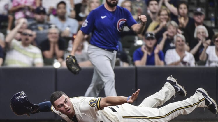 Jun 30, 2021; Milwaukee, Wisconsin, USA; Milwaukee Brewers right fielder Tyrone Taylor (15) reacts after scoring a run in the fourth inning as Chicago Cubs pitcher Rex Brothers (48) watches at American Family Field. Mandatory Credit: Benny Sieu-USA TODAY Sports