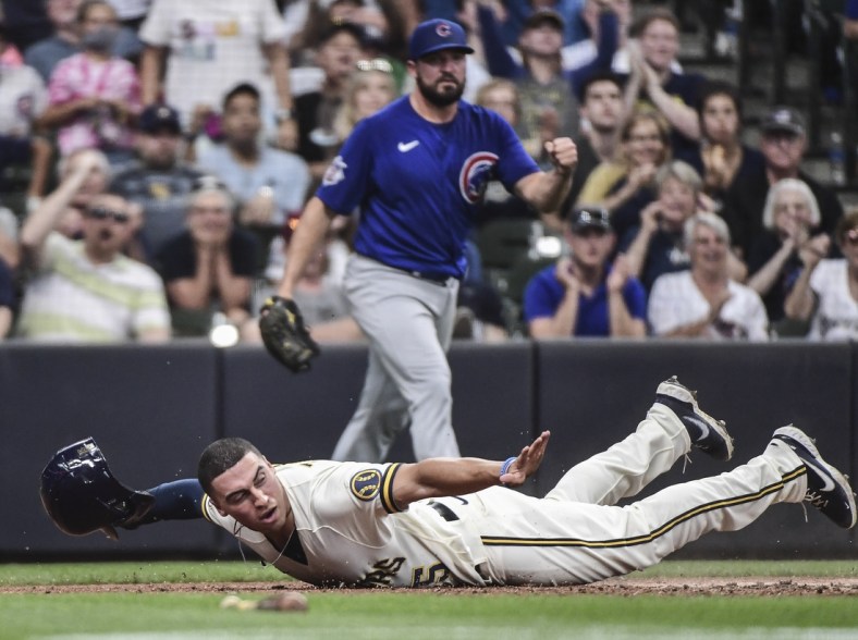 Jun 30, 2021; Milwaukee, Wisconsin, USA; Milwaukee Brewers right fielder Tyrone Taylor (15) reacts after scoring a run in the fourth inning as Chicago Cubs pitcher Rex Brothers (48) watches at American Family Field. Mandatory Credit: Benny Sieu-USA TODAY Sports