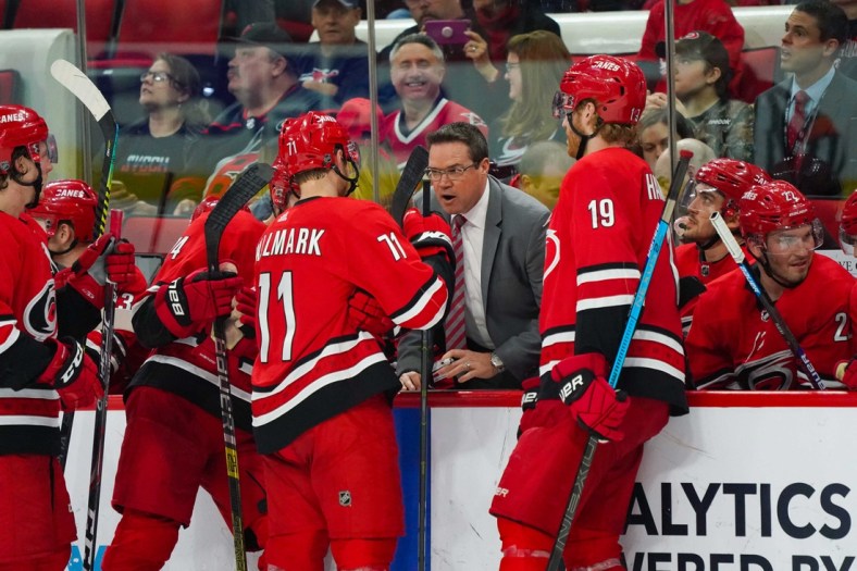 Apr 4, 2019; Raleigh, NC, USA;  Carolina Hurricanes assistant coach Dean Chynoweth talks to center Lucas Wallmark (71) and  defenseman Dougie Hamilton (19) during a time out against the New Jersey Devils at PNC Arena. The Carolina Hurricanes defeated the New Jersey Devils 3-1. Mandatory Credit: James Guillory-USA TODAY Sports