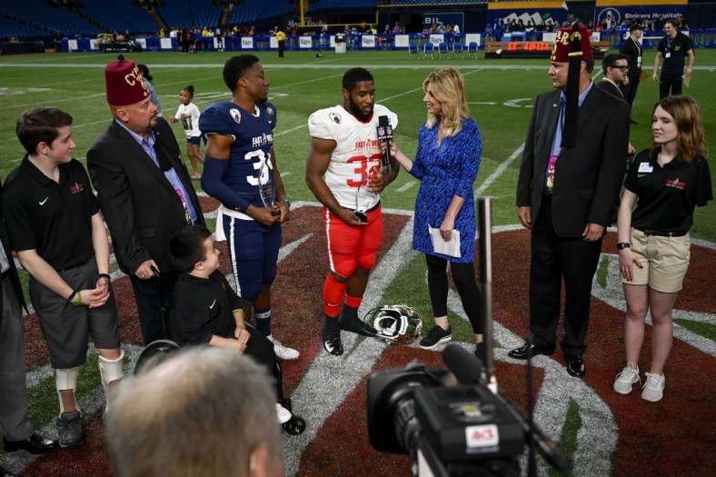 Jan 18, 2020; St. Petersburg, Florida, USA; Team East running back Benny LeMay (32) and Team West safety Luther Kirk (34) receive the trophy for defensive and offensive most valuable player respectively in the 95th East-West Shrine Bowl at Tropicana Field. Mandatory Credit: Douglas DeFelice-USA TODAY Sports