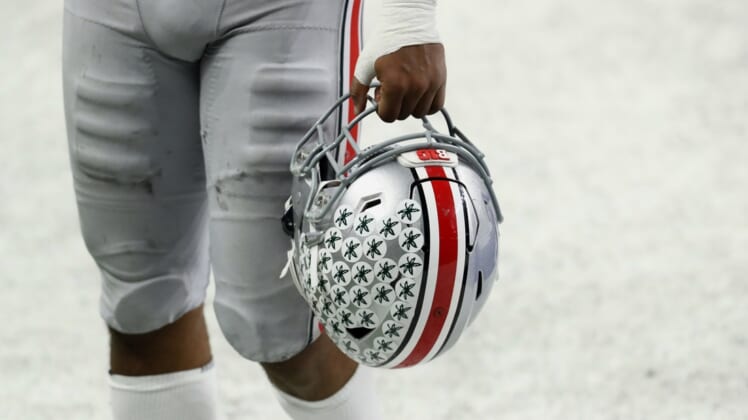 Dec 19, 2020; Indianapolis, Indiana, USA; A member of the Ohio State Buckeyes carries his helmet off the field after defeating the Northwestern Wildcats at Lucas Oil Stadium. Mandatory Credit: Aaron Doster-USA TODAY Sports