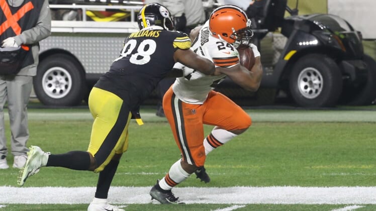 Jan 10, 2021; Pittsburgh, Pennsylvania, USA;  Cleveland Browns running back Nick Chubb (24) runs the ball against Pittsburgh Steelers inside linebacker Vince Williams (98) during the first quarter at Heinz Field. The Browns won 48-37. Mandatory Credit: Charles LeClaire-USA TODAY Sports