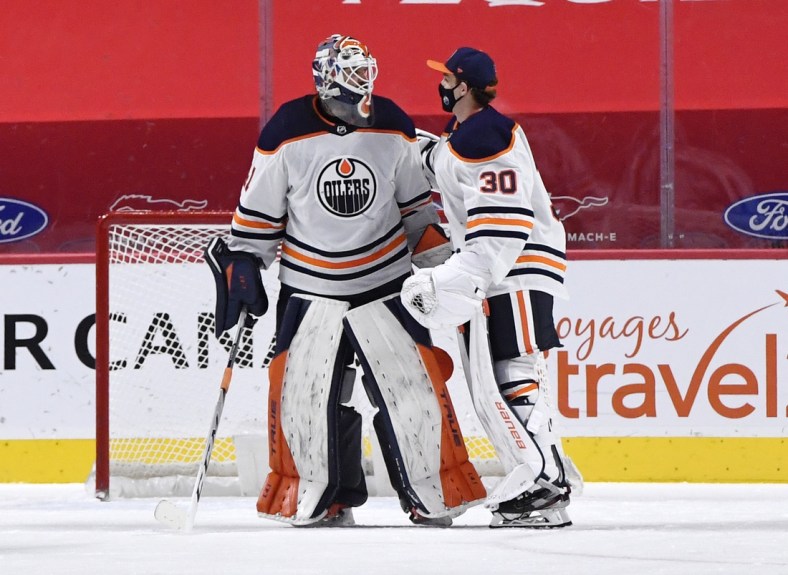 Feb 11, 2021; Montreal, Quebec, CAN; Edmonton Oilers goalie Mike Smith (41) celebrates the win over the Montreal Canadiens with teammate Dylan Wells (30) at the Bell Centre. Mandatory Credit: Eric Bolte-USA TODAY Sports