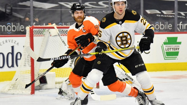 Feb 5, 2021; Philadelphia, Pennsylvania, USA; Boston Bruins defenseman Brandon Carlo (25) battles with Philadelphia Flyers center Claude Giroux (28) at Wells Fargo Center. Mandatory Credit: Eric Hartline-USA TODAY Sports