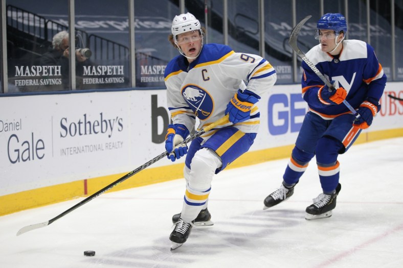Mar 4, 2021; Uniondale, New York, USA; Buffalo Sabres center Jack Eichel (9) plays the puck against New York Islanders defenseman Ryan Pulock (6) during the first period at Nassau Veterans Memorial Coliseum. Mandatory Credit: Brad Penner-USA TODAY Sports