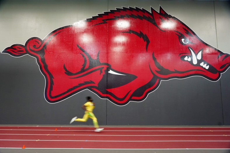 Mar 13, 2021; Fayetteville, Arkansas, USA; Ihemje Emmanuel of Kansas State warms up for the triple jump with the Arkansas Razorbacks logo as a backdrop during the NCAA Indoor Track and Field Championships at the Randal Tyson Center. Mandatory Credit: Kirby Lee-USA TODAY Sports
