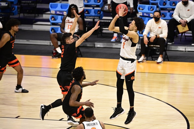 Mar 21, 2021; Indianapolis, Indiana, USA; Oklahoma State Cowboys guard Cade Cunningham (2) shoots while Oregon State Beavers guard Jarod Lucas (2) defends during the second half in the second round of the 2021 NCAA Tournament at Hinkle Fieldhouse. Mandatory Credit: Marc Lebryk-USA TODAY Sports