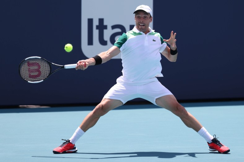 Apr 2, 2021; Miami, Florida, USA; Roberto Bautista Agut of Spain hits a forehand against Jannik Sinner of Italy (not pictured) in a men's singles semifinal in the Miami Open at Hard Rock Stadium. Mandatory Credit: Geoff Burke-USA TODAY Sports