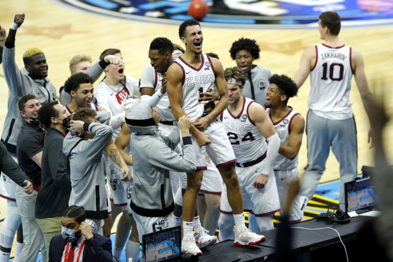 Gonzaga Bulldogs guard Jalen Suggs (1) leaps on a sideline table to celebrate after sinking a buzzer beater three-pointer to defeat UCLA in overtime during the semifinals of the Final Four of the 2021 NCAA Tournament on Saturday, April 3, 2021, at Lucas Oil Stadium in Indianapolis, Ind. Mandatory Credit: Robert Scheer/IndyStar via USA TODAY Sports
