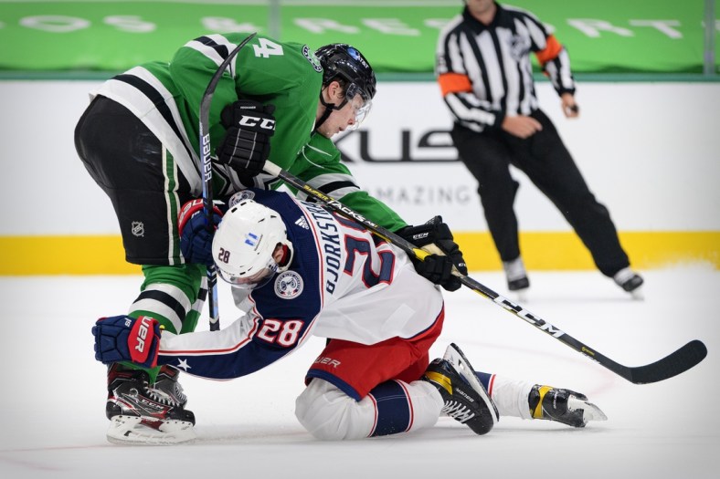 Apr 15, 2021; Dallas, Texas, USA; Columbus Blue Jackets right wing Oliver Bjorkstrand (28) collides with Dallas Stars defenseman Miro Heiskanen (4) during the first period at the American Airlines Center. Mandatory Credit: Jerome Miron-USA TODAY Sports