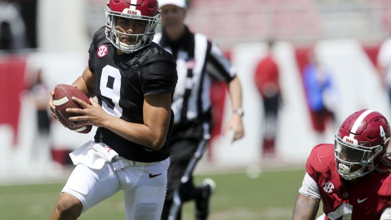 Apr 17, 2021; Tuscaloosa, Alabama, USA; White quarterback Bryce Young (9) scrambles for a first down after moving away from Crimson linebacker Christopher Allen (4) during the Alabama A-Day game at Bryant-Denny Stadium. Mandatory Credit: Gary Cosby-USA TODAY Sports