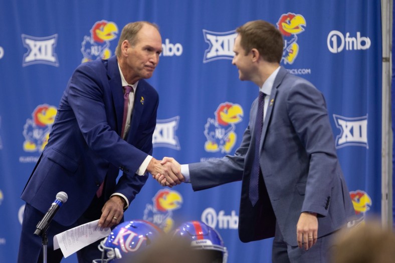 The University of Kansas new football coach Lance Leipold, left, shakes hands with athletic director Travis Goff, right, during a news conference Monday at the indoor football facility.