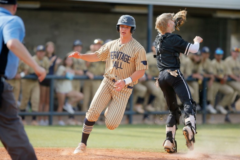Heritage Hall's Jackson Jobe scores a run past Evan Anderson of Verdigris during a Class 4A baseball state tournament championship game between Heritage Hall and Verdigris in Shawnee, Okla., Saturday, May 15, 2021.

Lx13916