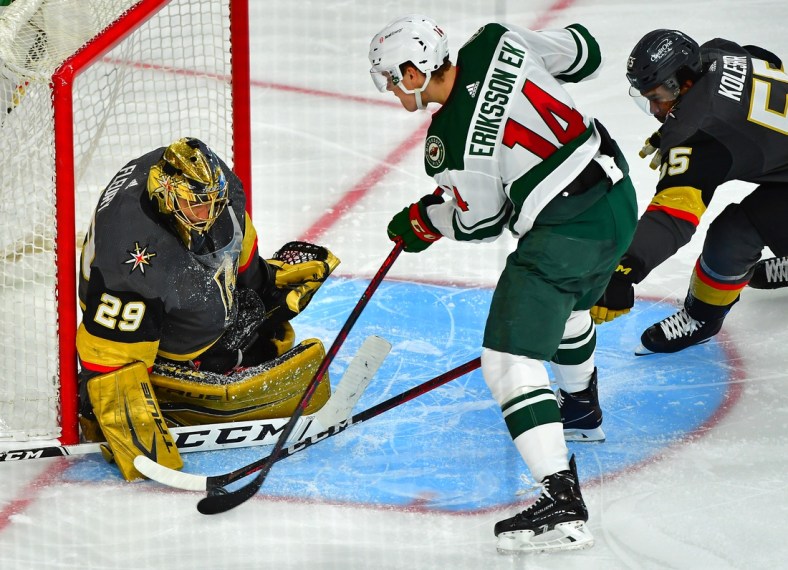 May 16, 2021; Las Vegas, Nevada, USA; Vegas Golden Knights right wing Keegan Kolesar (55) reaches in to deflect a shot by Minnesota Wild center Joel Eriksson Ek (14) as Vegas Golden Knights goaltender Marc-Andre Fleury (29) defends his net during the second period of game one of the first round of the 2021 Stanley Cup Playoffs at T-Mobile Arena. Mandatory Credit: Stephen R. Sylvanie-USA TODAY Sports