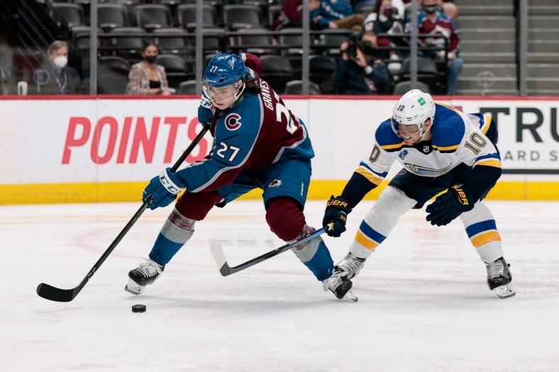 May 19, 2021; Denver, Colorado, USA; Colorado Avalanche defenseman Ryan Graves (27) controls the puck under pressure from St. Louis Blues center Brayden Schenn (10) in the third period in game two of the first round of the 2021 Stanley Cup Playoffs at Ball Arena. Mandatory Credit: Isaiah J. Downing-USA TODAY Sports