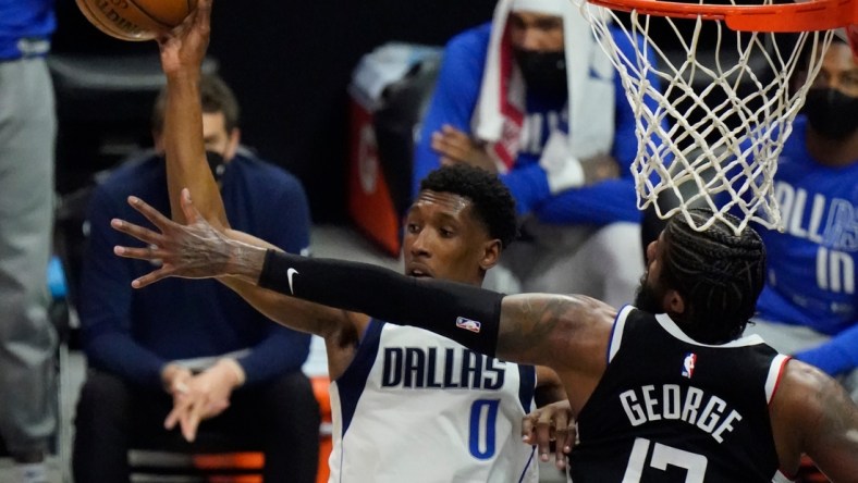 May 22, 2021; Los Angeles, California, USA; Dallas Mavericks guard Josh Richardson (0) hangs in the air as he passes off top a teammate as LA Clippers guard Paul George (13) defends in the second quarter of game one in the first round of the 2021 NBA Playoffs at Staples Center. Mandatory Credit: Robert Hanashiro-USA TODAY Sports