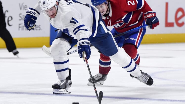 May 25, 2021; Montreal, Quebec, CAN; Toronto Maple Leafs forward Zach Hyman (11) plays the puck and Montreal Canadiens forward Cole Caufield (22) gives chase during the third period in game four of the first round of the 2021 Stanley Cup Playoffs at Bell Centre. Mandatory Credit: Eric Bolte-USA TODAY Sports