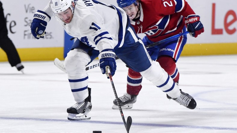 May 25, 2021; Montreal, Quebec, CAN; Toronto Maple Leafs forward Zach Hyman (11) plays the puck and Montreal Canadiens forward Cole Caufield (22) gives chase during the third period in game four of the first round of the 2021 Stanley Cup Playoffs at Bell Centre. Mandatory Credit: Eric Bolte-USA TODAY Sports