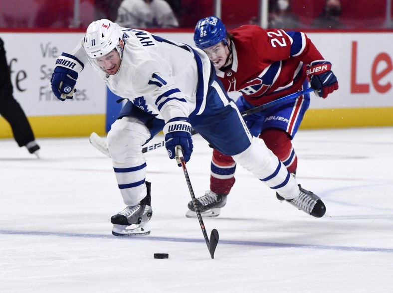 May 25, 2021; Montreal, Quebec, CAN; Toronto Maple Leafs forward Zach Hyman (11) plays the puck and Montreal Canadiens forward Cole Caufield (22) gives chase during the third period in game four of the first round of the 2021 Stanley Cup Playoffs at Bell Centre. Mandatory Credit: Eric Bolte-USA TODAY Sports