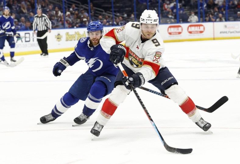 May 26, 2021; Tampa, Florida, USA; Florida Panthers forward Sam Bennett (9) skates with the puck as Tampa Bay Lightning center Brayden Point (21) defends during the third period during game six of the first round of the 2021 Stanley Cup Playoffs at Amalie Arena. Mandatory Credit: Kim Klement-USA TODAY Sports