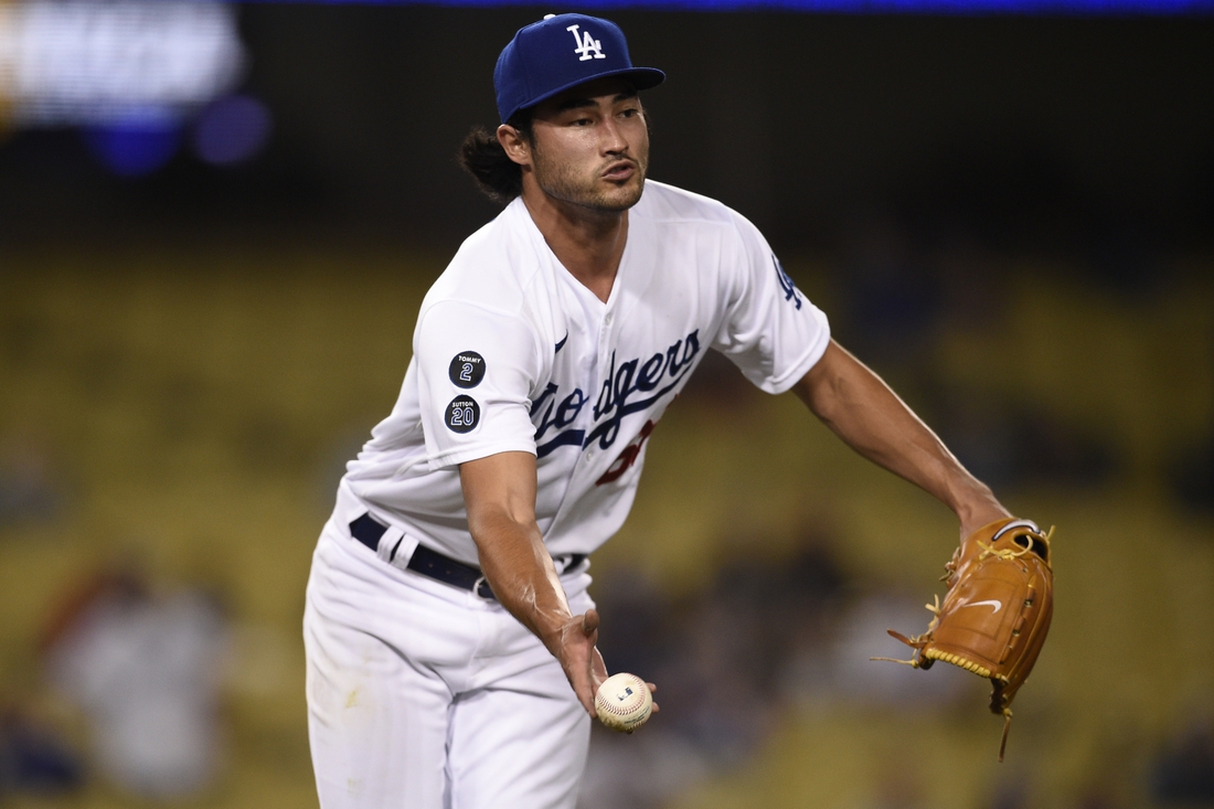 Jun 11, 2021; Los Angeles, California, USA; Los Angeles Dodgers pitcher Mitch White (66) tosses the ball to first to force an out during the ninth inning against the Texas Rangers at Dodger Stadium. Mandatory Credit: Kelvin Kuo-USA TODAY Sports