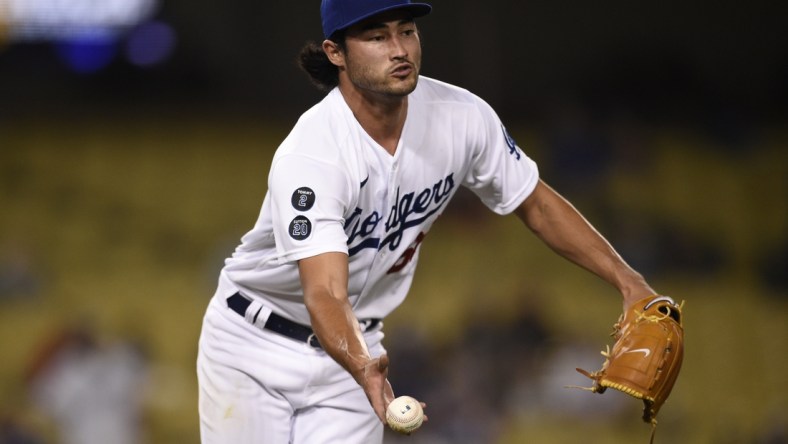 Jun 11, 2021; Los Angeles, California, USA; Los Angeles Dodgers pitcher Mitch White (66) tosses the ball to first to force an out during the ninth inning against the Texas Rangers at Dodger Stadium. Mandatory Credit: Kelvin Kuo-USA TODAY Sports