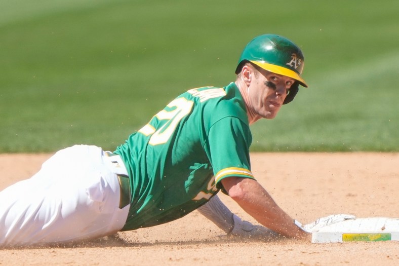 Jun 13, 2021; Oakland, California, USA;  Oakland Athletics left fielder Mark Canha (20) slides back towards second base during the sixth inning against the Kansas City Royals at RingCentral Coliseum. Mandatory Credit: Stan Szeto-USA TODAY Sports