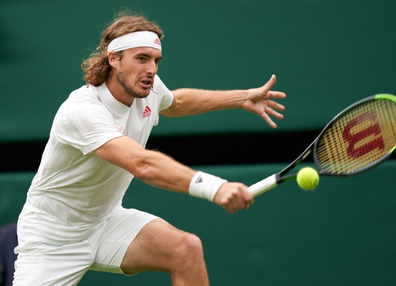 Jun 28, 2021; London, United Kingdom;   Stefanos Tsitsipas of Greece in action against third seed Francis Tiafoe (USA) on Court Number one in the first round at All England Lawn Tennis and Croquet Club. Mandatory Credit: Peter van den Berg-USA TODAY Sports