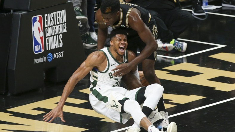 Jun 29, 2021; Atlanta, Georgia, USA; Milwaukee Bucks forward Giannis Antetokounmpo (34) and Atlanta Hawks center Clint Capela (15) fall to the floor as Antetokounmpo (34) is injured on the play in the third quarter during game four of the Eastern Conference Finals for the 2021 NBA Playoffs at State Farm Arena. Mandatory Credit: Brett Davis-USA TODAY Sports