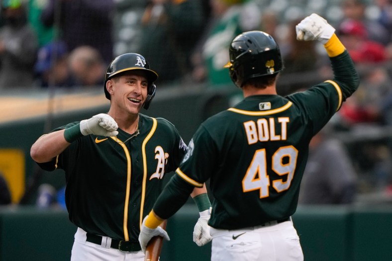 Jun 30, 2021; Oakland, California, USA;  Oakland Athletics designated hitter Frank Schwindel (45) celebrates with center fielder Skye Bolt (49) after hitting a two-run home run during the second inning against the Texas Rangers at RingCentral Coliseum. Mandatory Credit: Stan Szeto-USA TODAY Sports