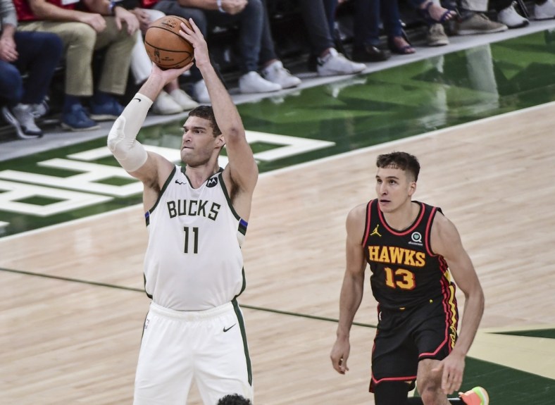 Jul 1, 2021; Milwaukee, Wisconsin, USA; Milwaukee Bucks center Brook Lopez (11) takes a shot against Atlanta Hawks guard Bogdan Bogdanovic (13) in the second quarter during game five of the Eastern Conference Finals for the 2021 NBA Playoffs at Fiserv Forum. Mandatory Credit: Benny Sieu-USA TODAY Sports