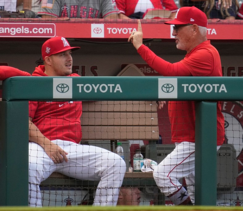 Jul 2, 2021; Anaheim, California, USA; Los Angeles Angels manager Joe Maddon talks to injured outfielder Mike Trout before the Angels game against the Baltimore Orioles at Angel Stadium. Mandatory Credit: Robert Hanashiro-USA TODAY Sports